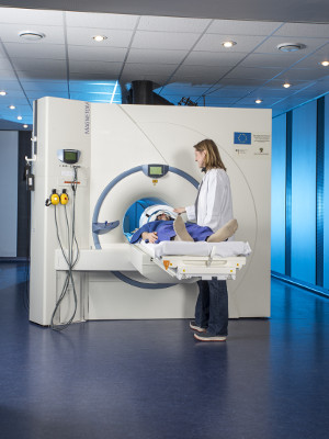 A researcher puts a patient in the MRI